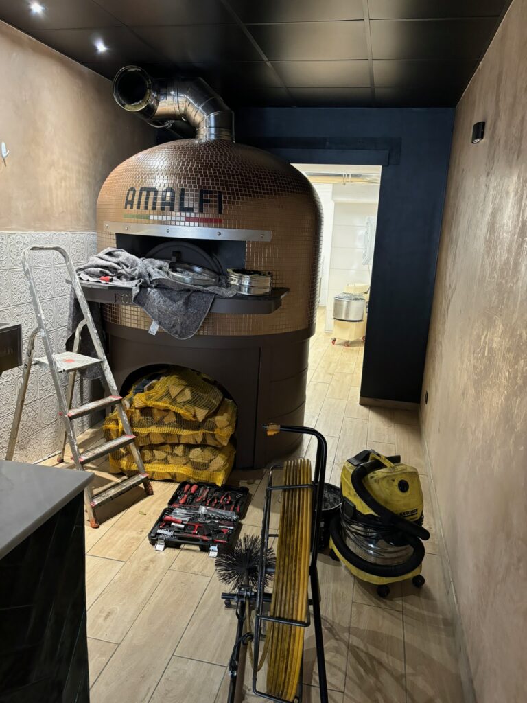 Un four à bois professionnel en cours de ramonage pour assurer un bon tirage et une combustion optimale à Chelles.